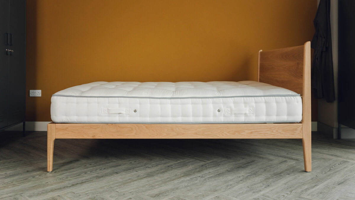 The Camden mid century style bed here in a kingsize and made in solid oak wood shown without bedding and from the side