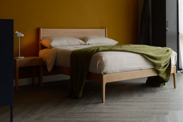 Our retro style Camden bed made from solid oak wood shown with matching bedside table and ecru linen bedding