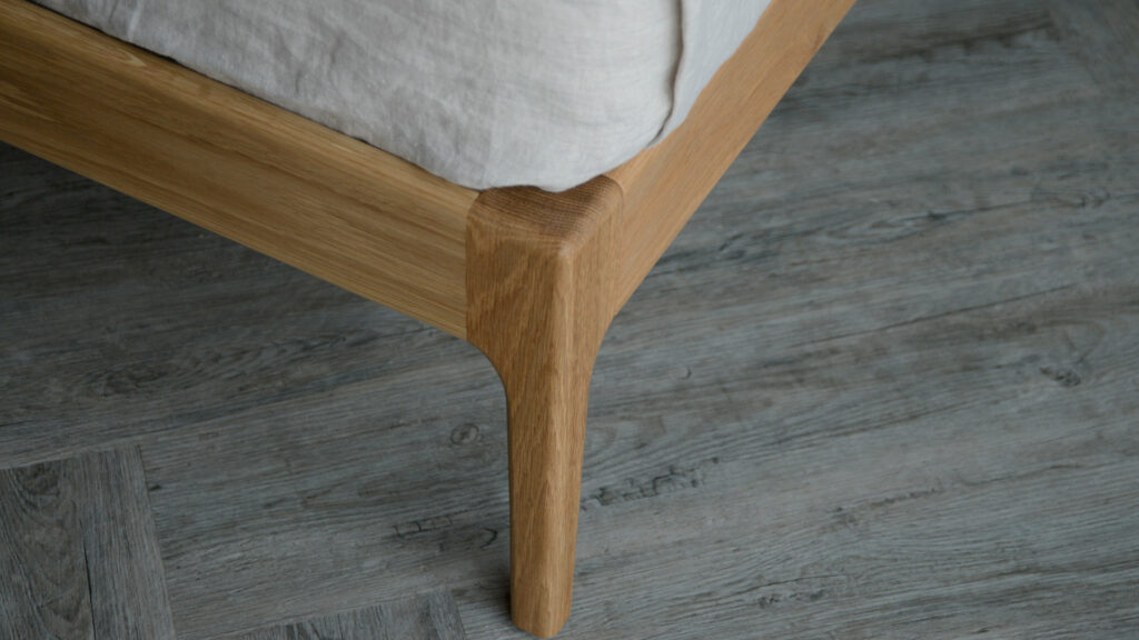 A close up of the foot end leg of our mid century style Camden bed made from solid oak wood