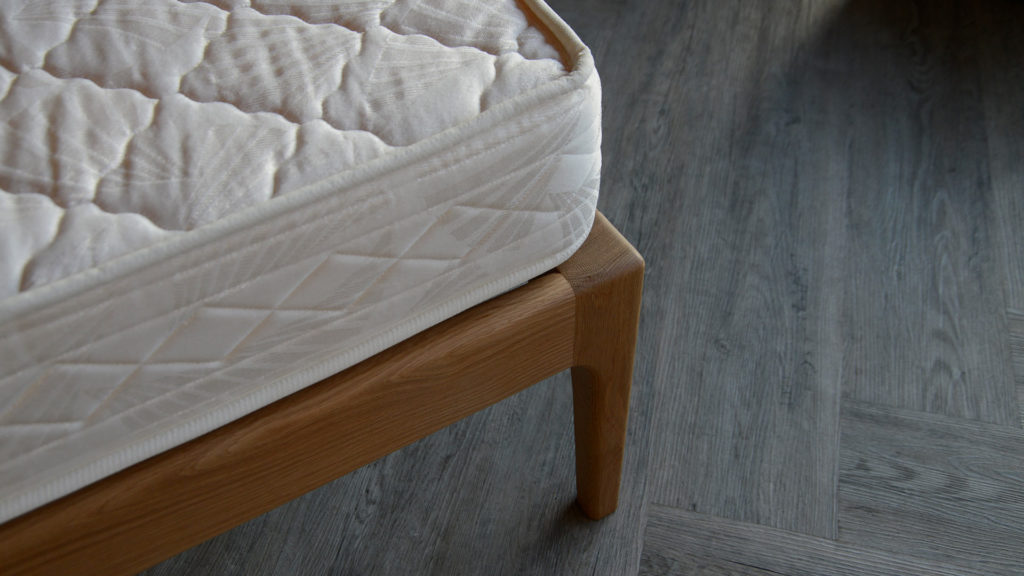 A closer view of the curving solid wood leg of our Camden wooden bed