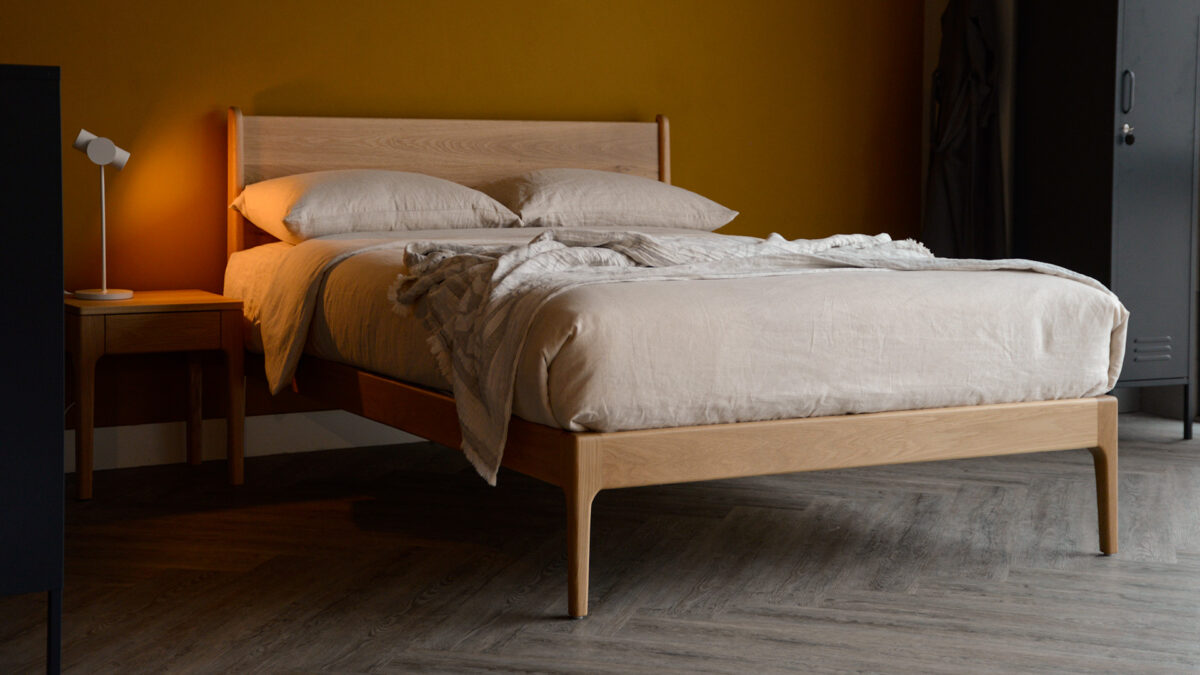 Our retro style Camden bed made from solid oak wood and shown with ecru linen bedding