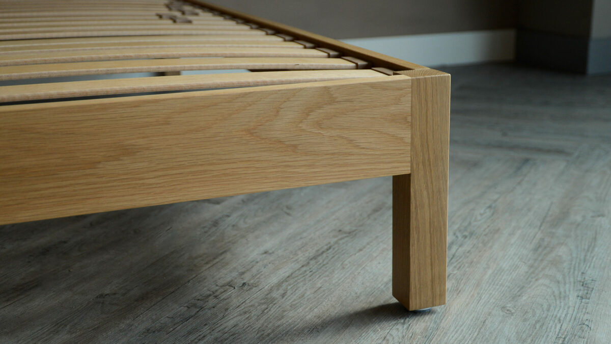 a close up view of the leg of a solid oak Malabar bed