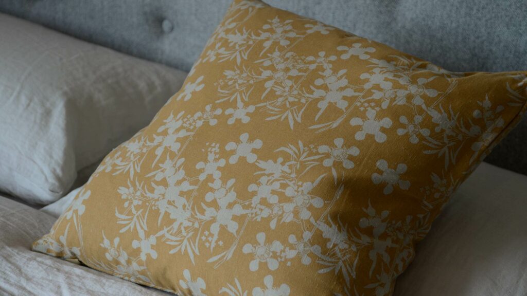 floral print cushion in a deep yellow ochre colour