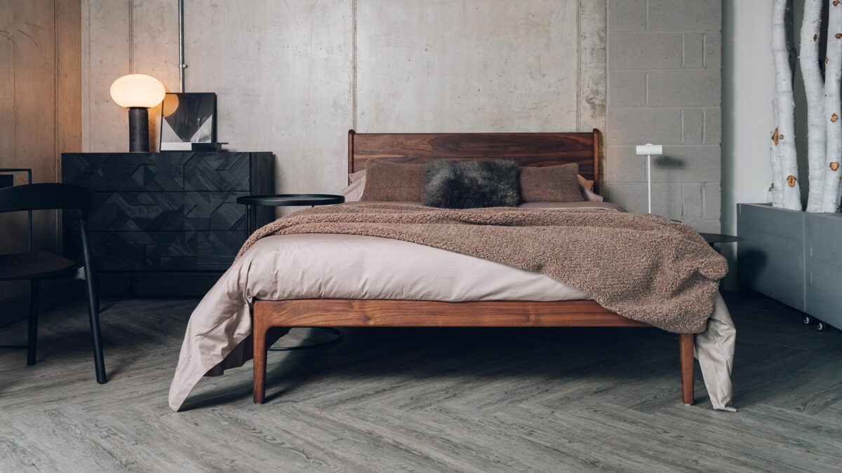striking oiled walnut Kingsize Camden bed with taupe bedding and black storage chest