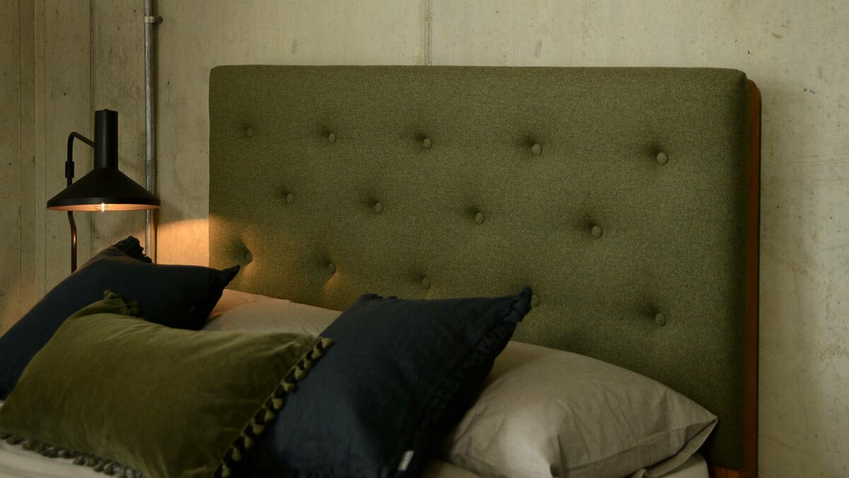 The tall upholstered and buttoned Skye bed headboard