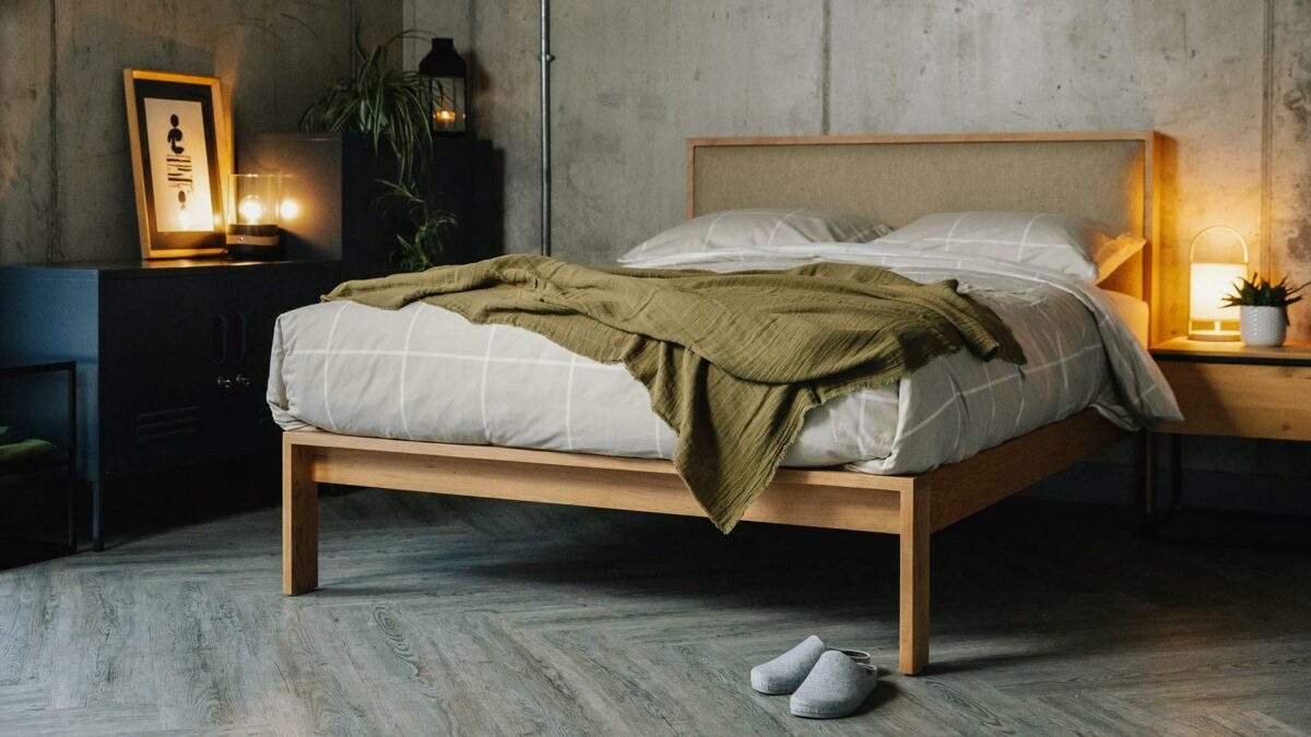 cosy concrete bedroom with wooden Shetland bed with padded headboard