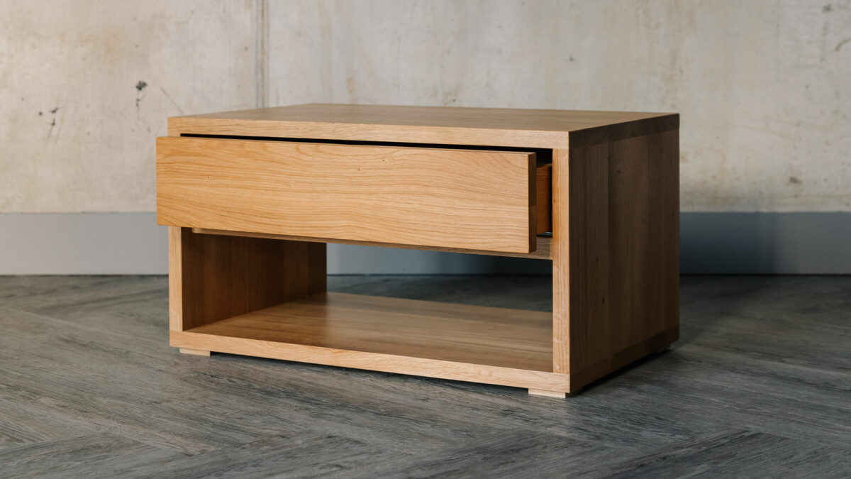 low bedside table with drawer and open shelf and made from solid oak