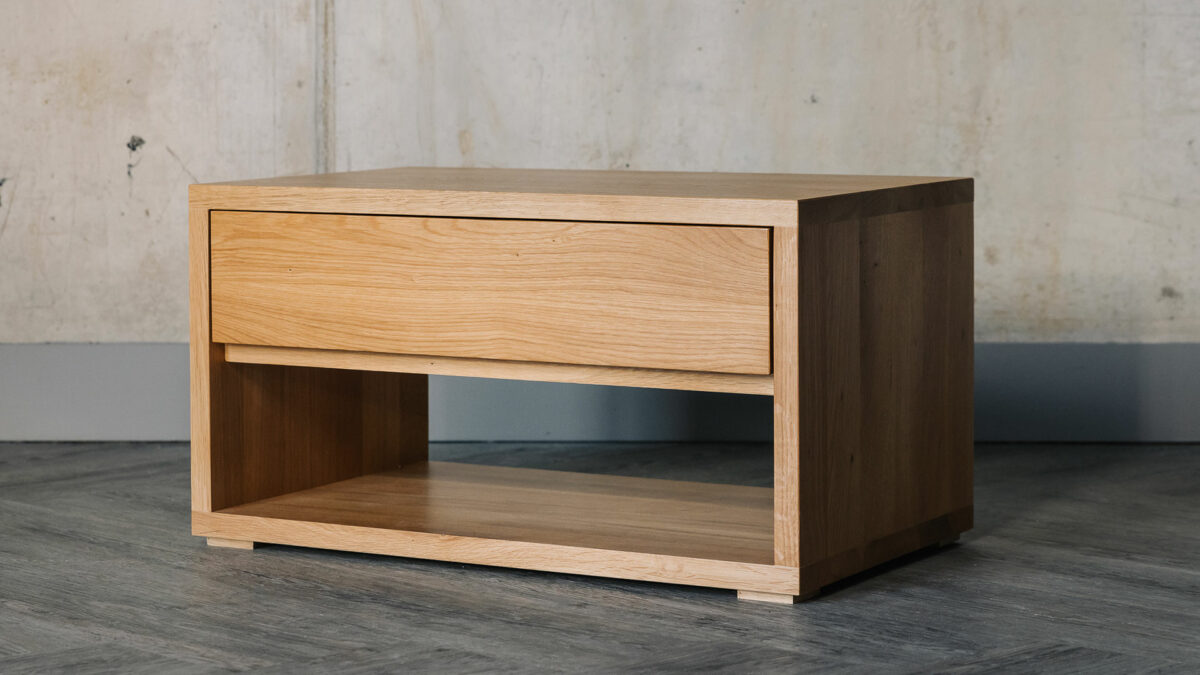 low bedside storage unit with a drawer and open shelf and made from solid oak