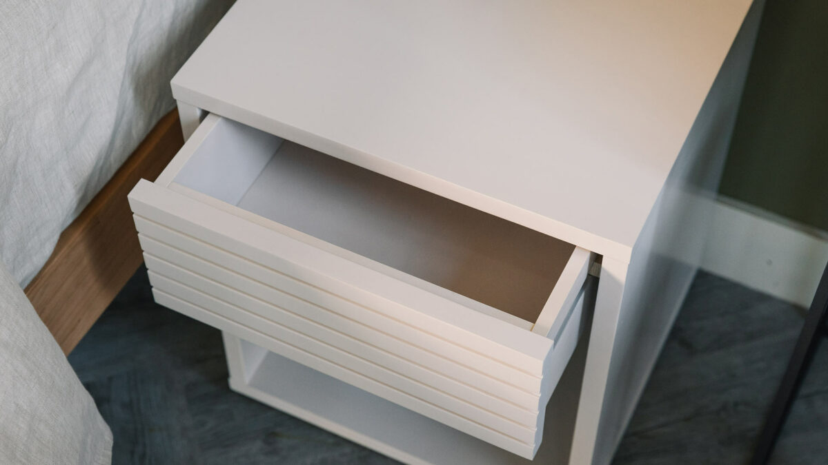 open drawer on white bedside unit