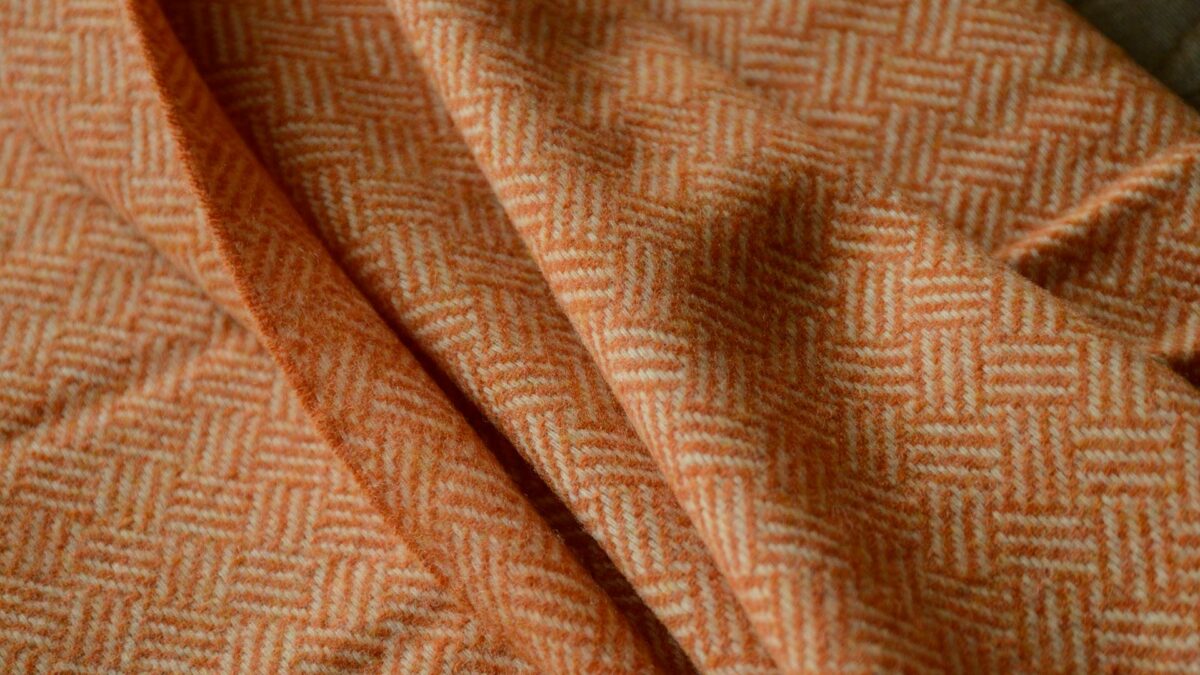 Basket weave lambswool throw in orange and ivory