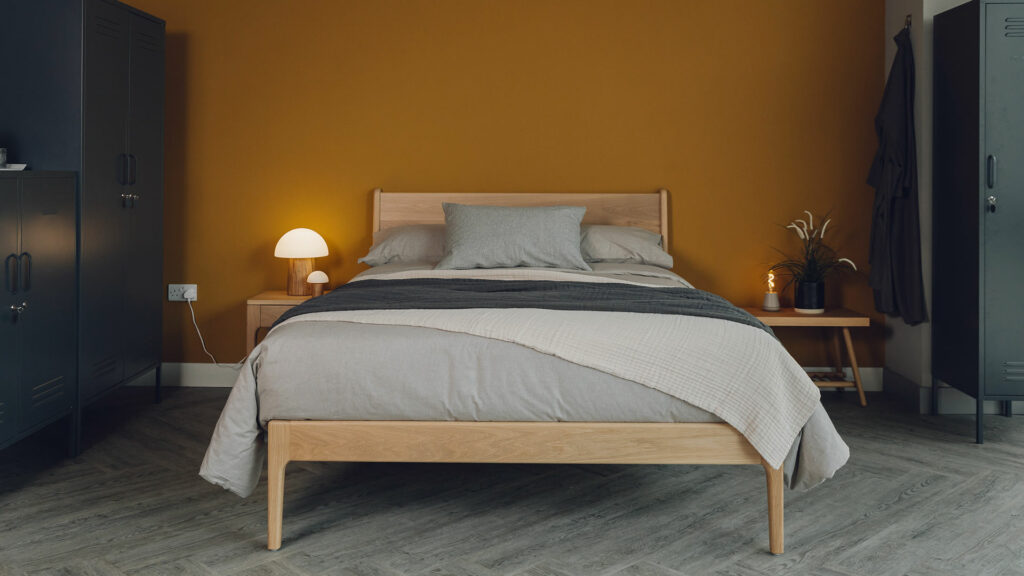 Autumnal bedroom style rich ochre walls, an oak Camden bed and stone and grey bedding