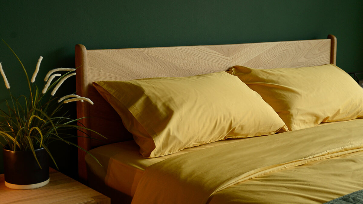 bamboo fibre and cotton duvet set in mustard yellow on a handcrafted oak bed