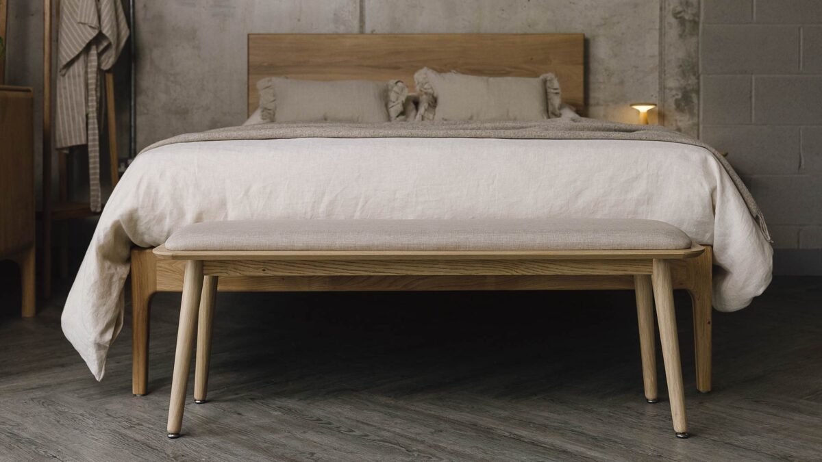 oak bed with neural bedding. Oak bench with padded seat at the foot.