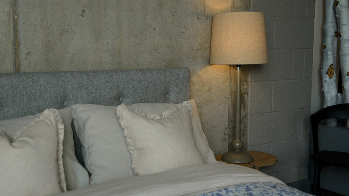 a painted wooden lamp base with linen colour shade used as a bedside light