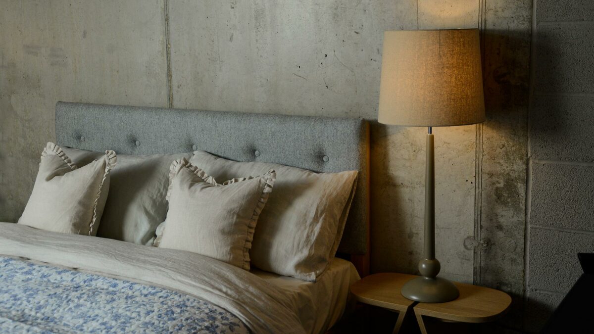 a painted wooden lamp base with linen colour shade used as a bedside light