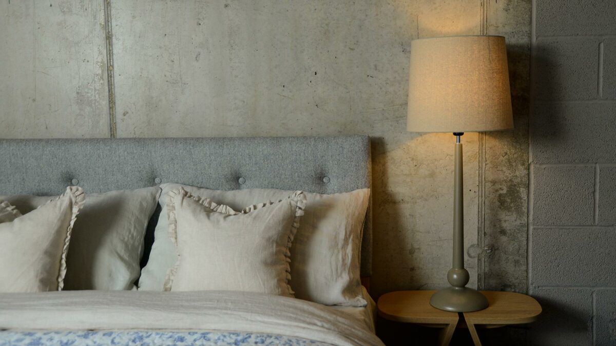 a painted wooden lamp base with linen colour shade used as a bedside light