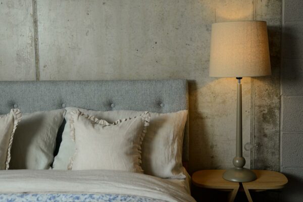 a painted wooden lamp base with linen colour shade used as a bedside light