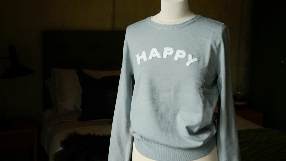 pale blue jumper with white happy motif