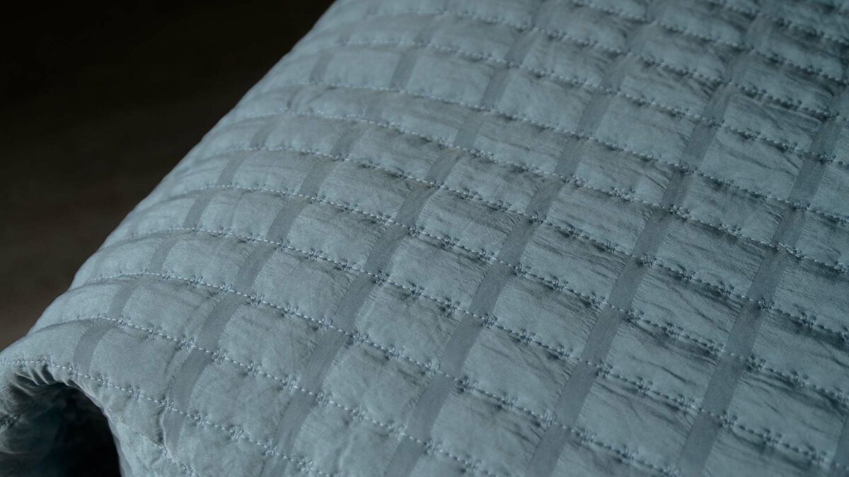 dimpled lightly quilted bedspread in pale blue/teal, a close-up of the texture