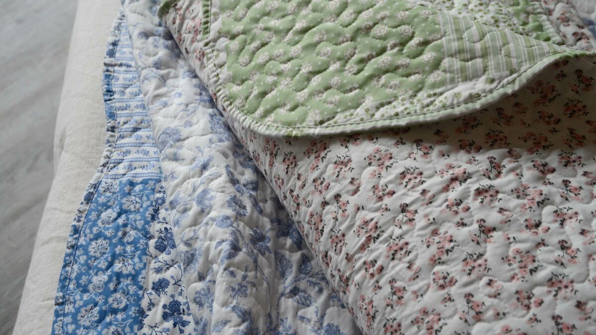 Reversible quilted bedspreads in Blue and Green colours, floral design one side and patchwork patterns the other