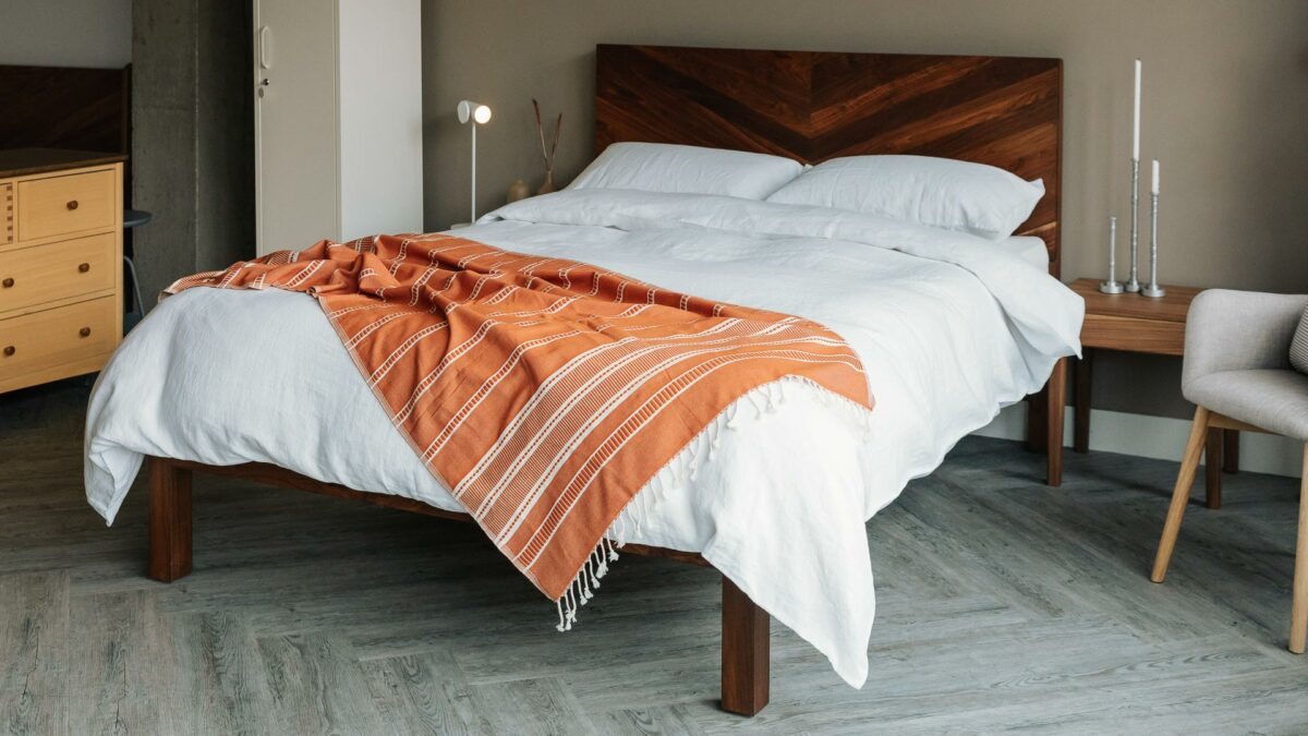 white linen bedding on Walnut hathersage bed base wit orange turkish throw