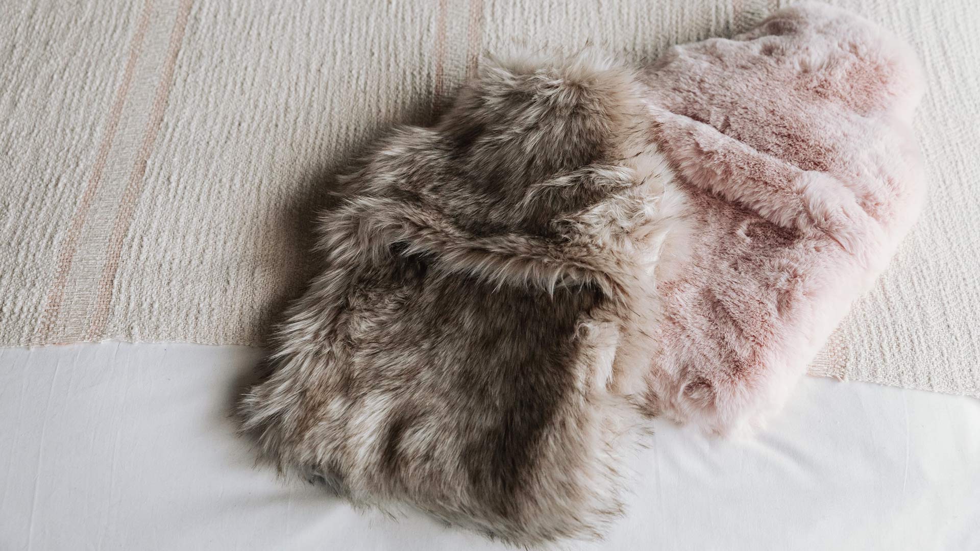 pink coloured faux-fur covered hot water bottles