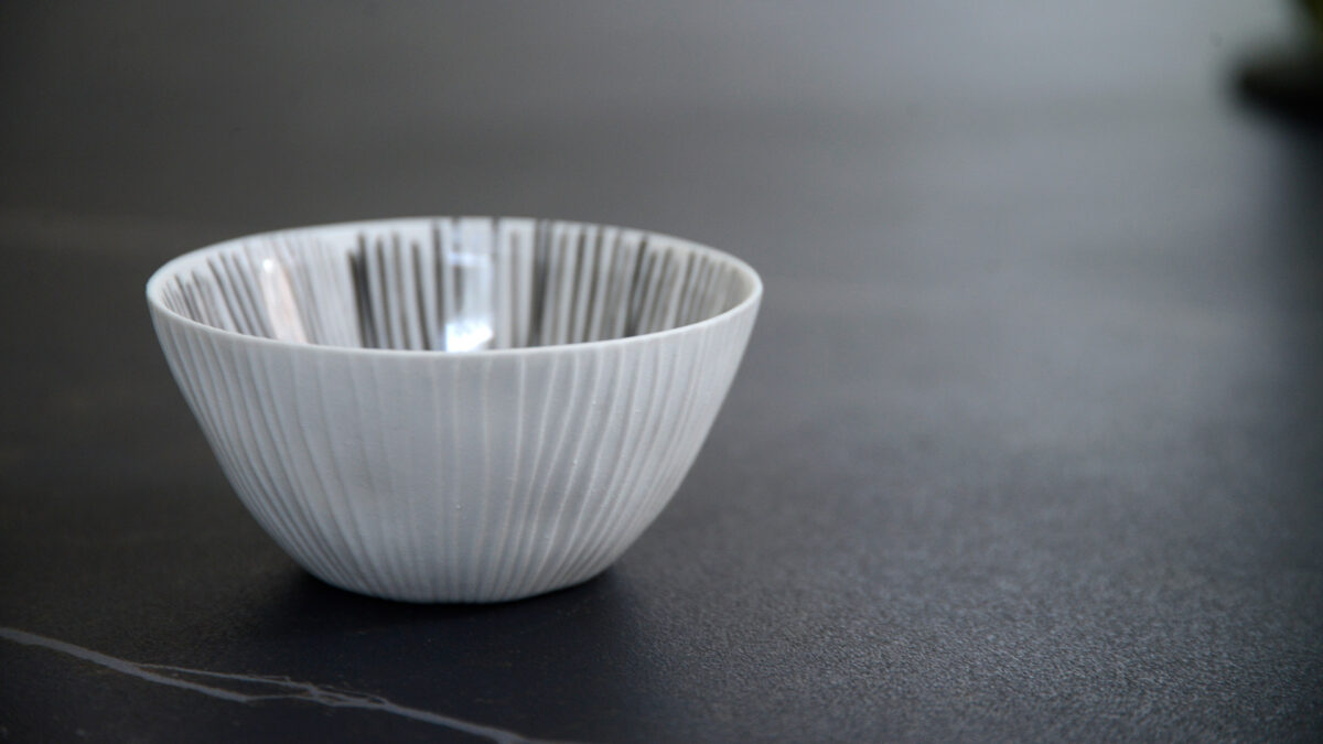 small ribbed porcelain bowl with painted grey stripes to the inside