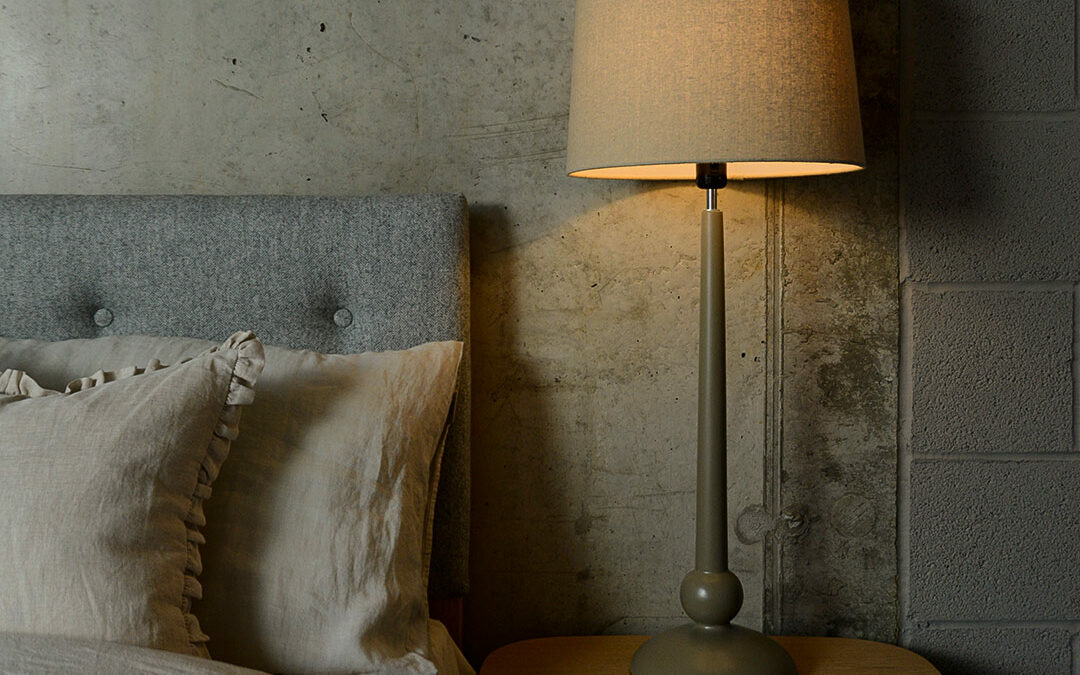 a painted wooden lamp base with linen colour shade used as a bedside light