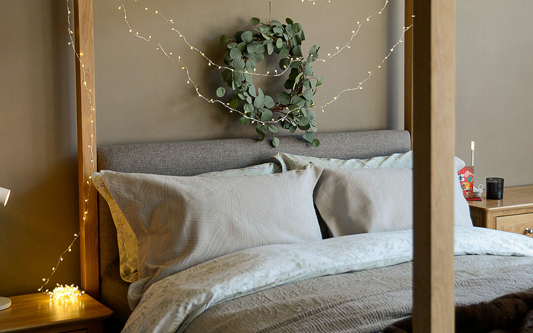 Christmas bedroom with LED string lights and Highland 4-poster bed in oak