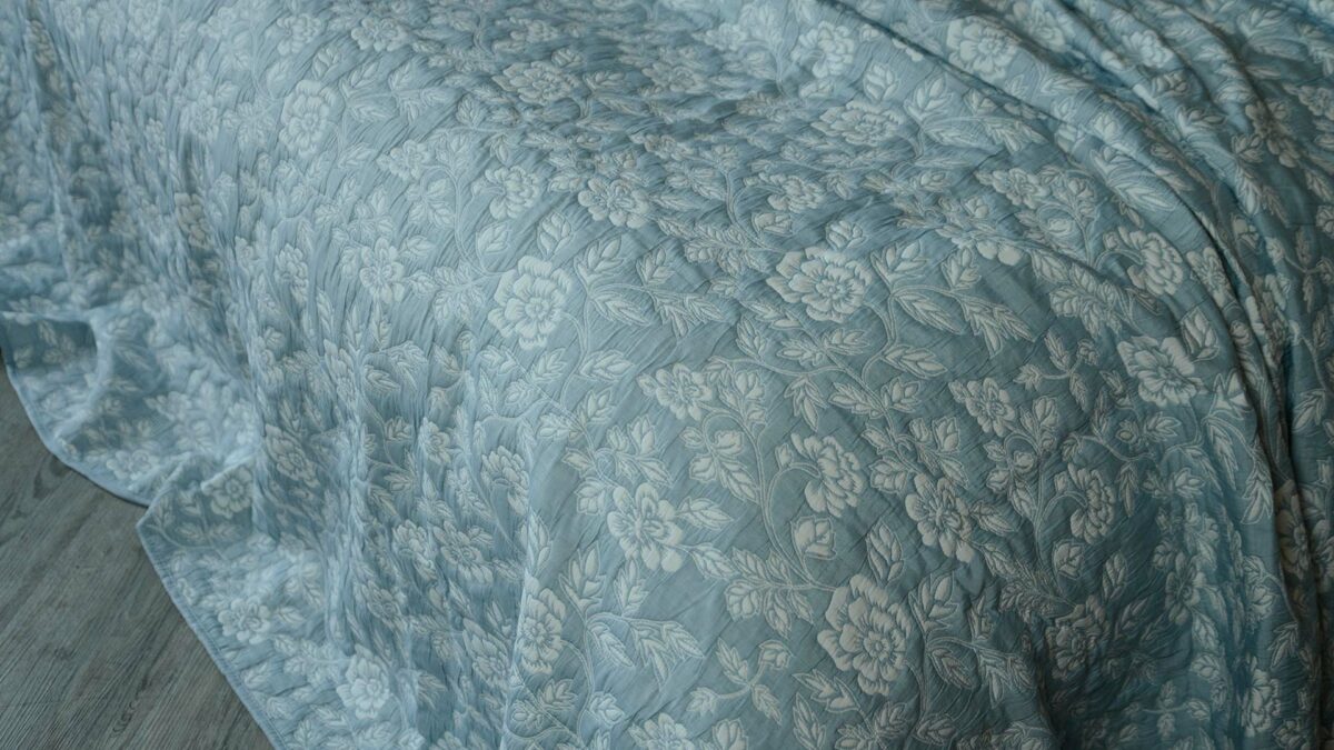 Wedgwood blue and ivory floral patterned reversible quilted bedspread