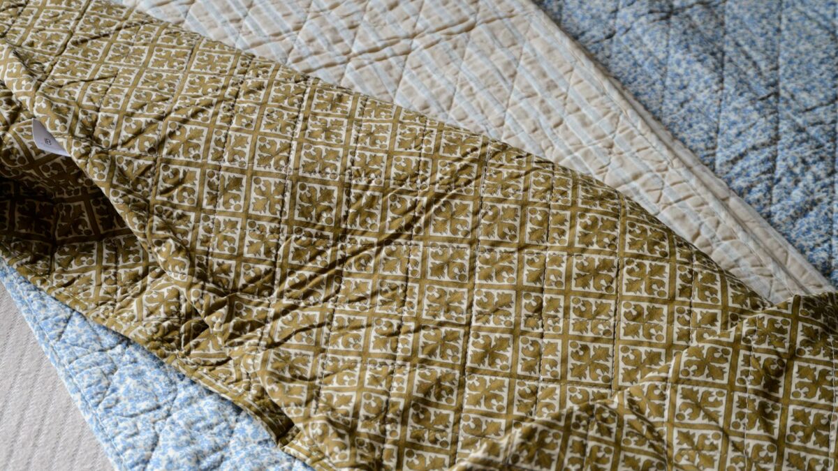 printed cotton quilts in gold cream and blue