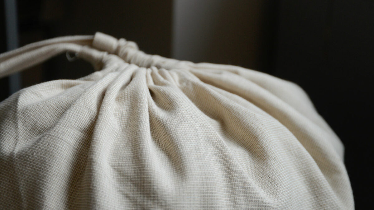 pale beige draw string laundry bag shown close up