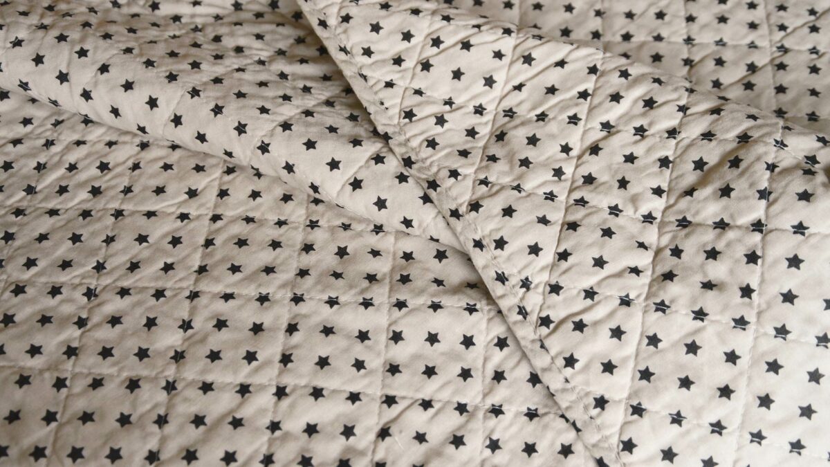 Quilted ivory throw with small black stars print