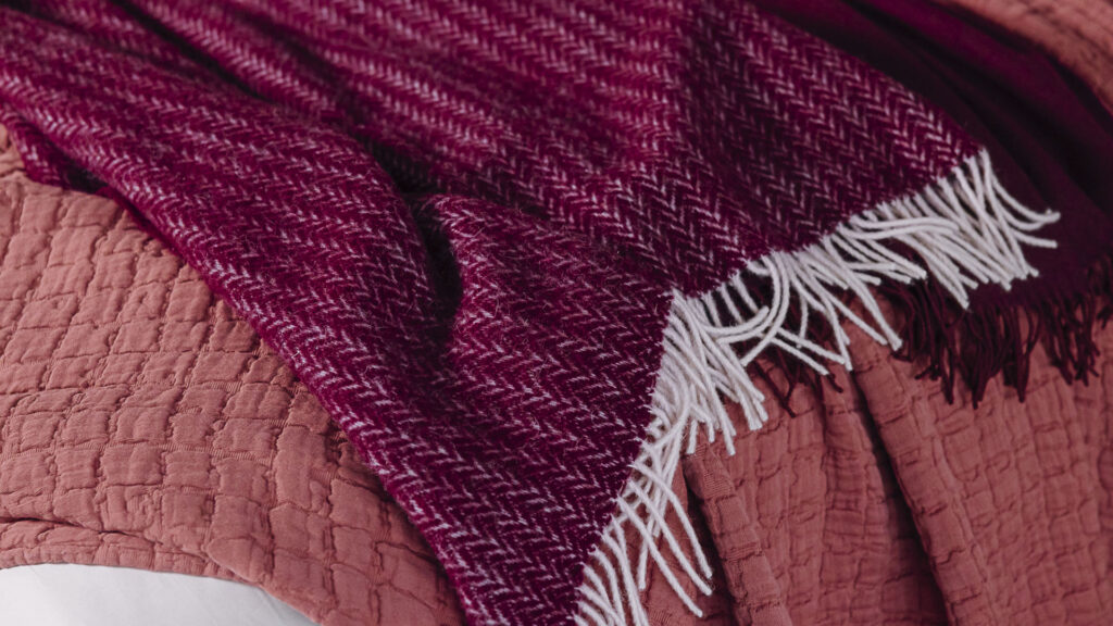 close up of 3 throws in shades of raspberry and deep wine.