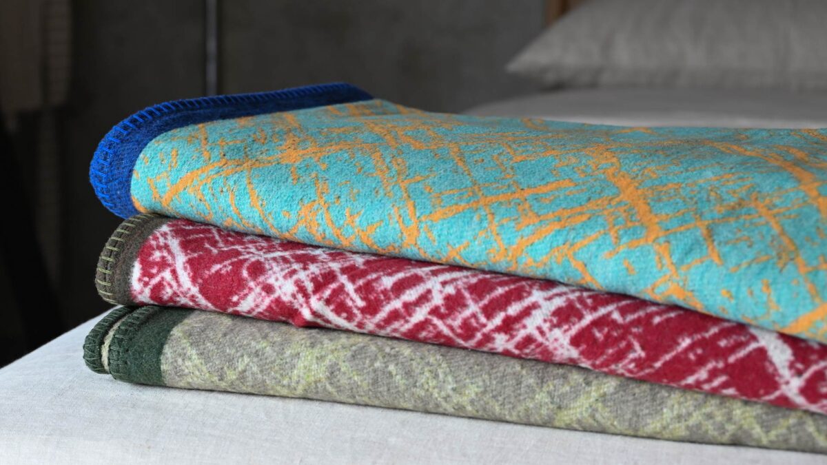 Crosshatch throws in various colours neatly folded and stacked.