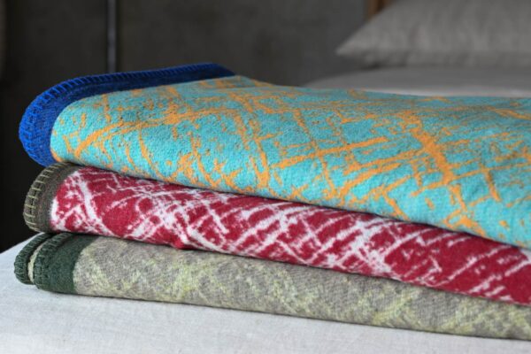 Crosshatch throws in various colours neatly folded and stacked.