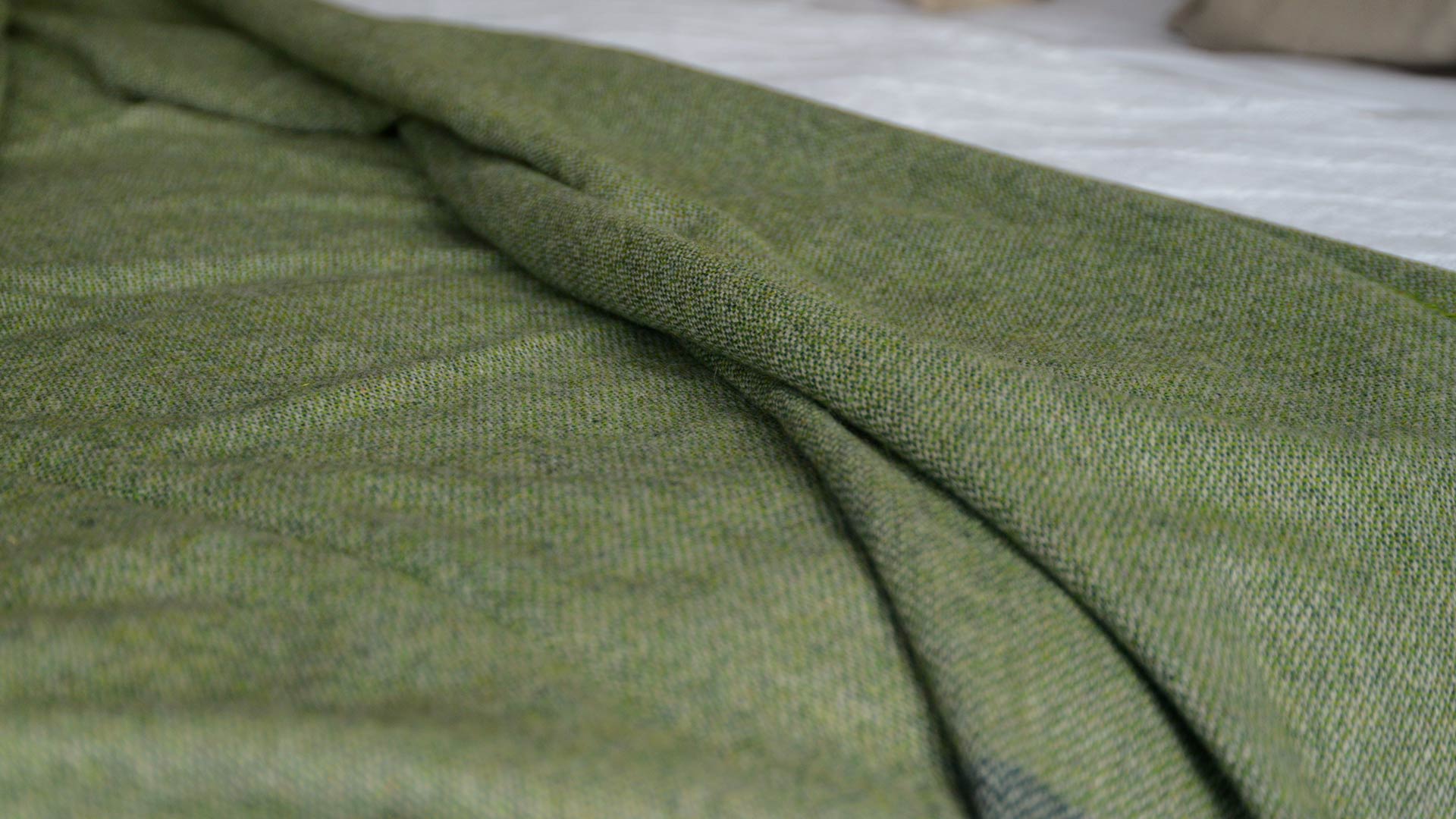 tweedy green recycled wool cosy throw with fringed edges
