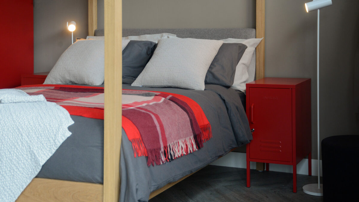 bedside metal locker in lipstick red shown with our Highland 4 poster bed