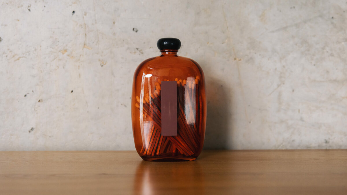 red matches set in glass bottle with strike paper