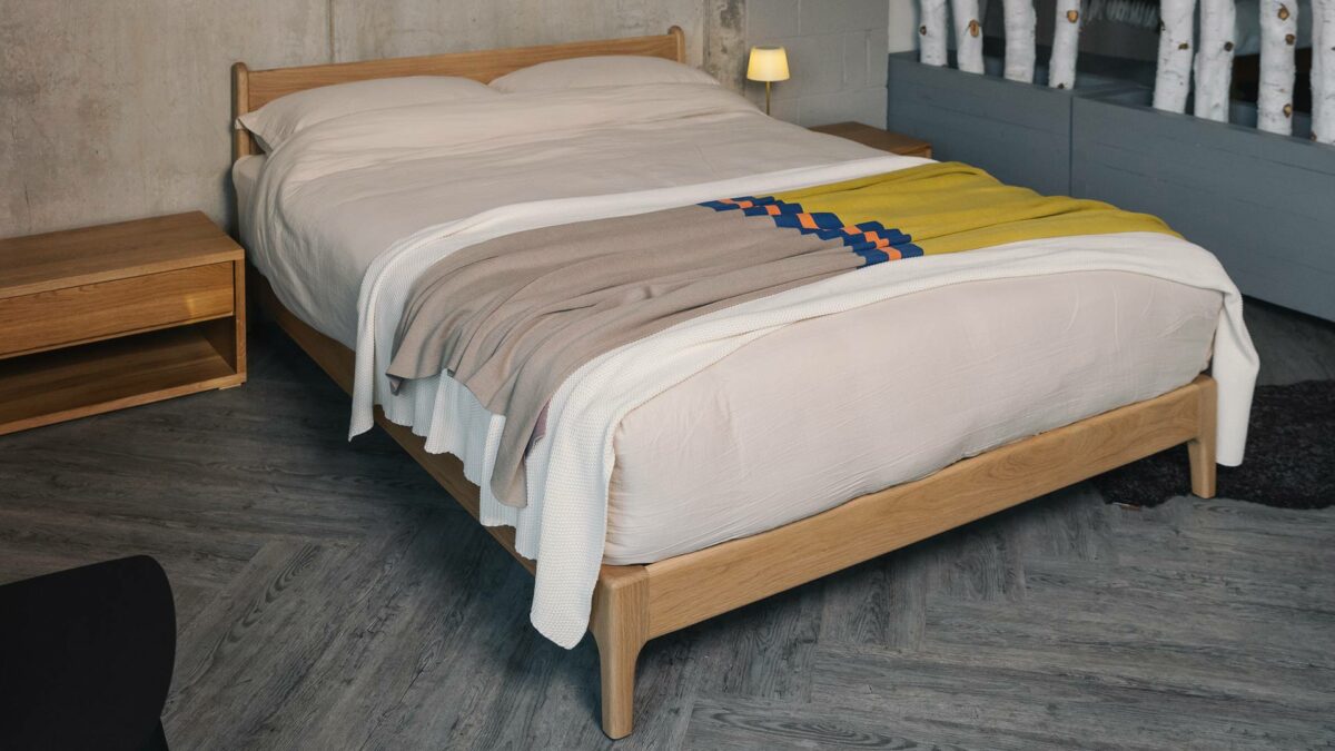 reversible colour block throw shown on a kingsize bed