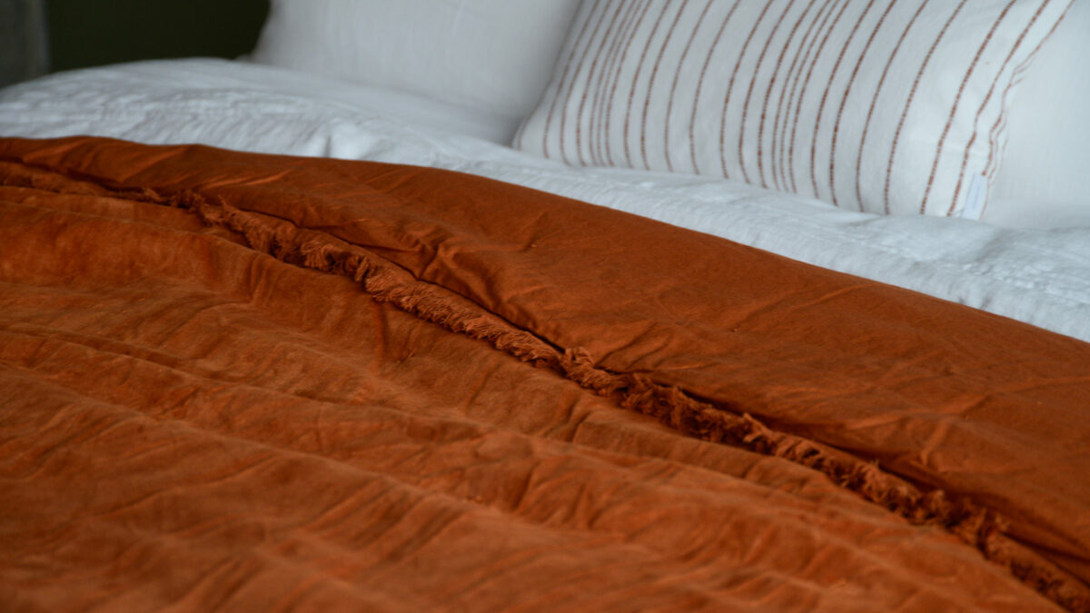 reversible velevt throw with fringe detail in burnt orange