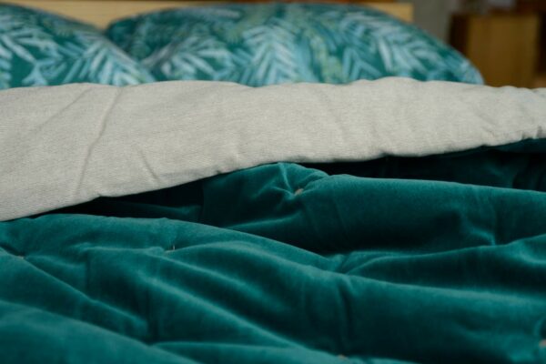 reversible quilted throw in teal coloured velvet and linen like cotton.