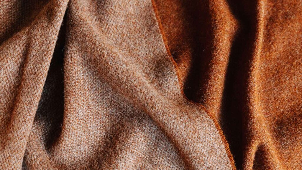 a closer view of the rusty red marl reversible wool throw