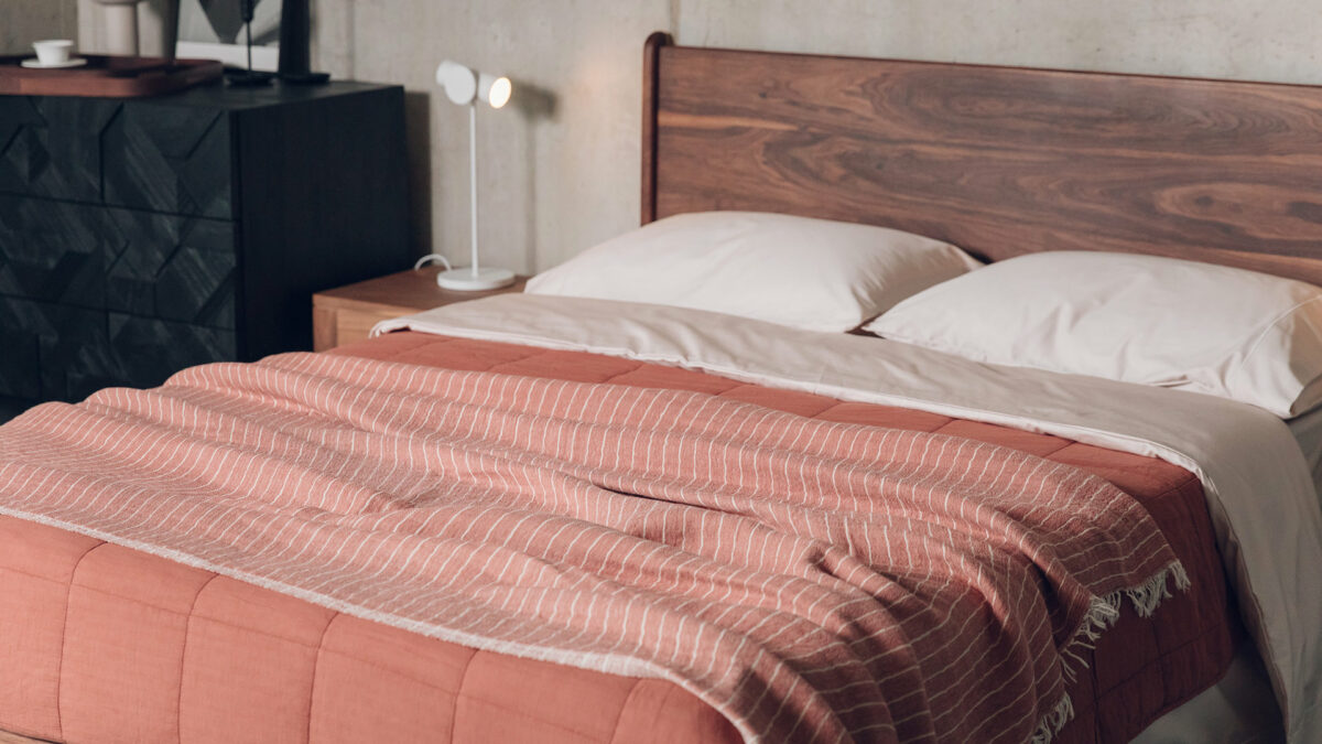rust red and terracotta throws on walnut bed with shell bedding