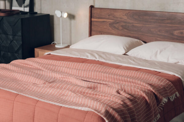 rust red and terracotta throws on walnut bed with shell bedding