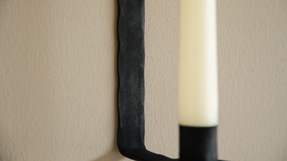 rustic detail hammered effect black metal wall mounted candlestick holder close up
