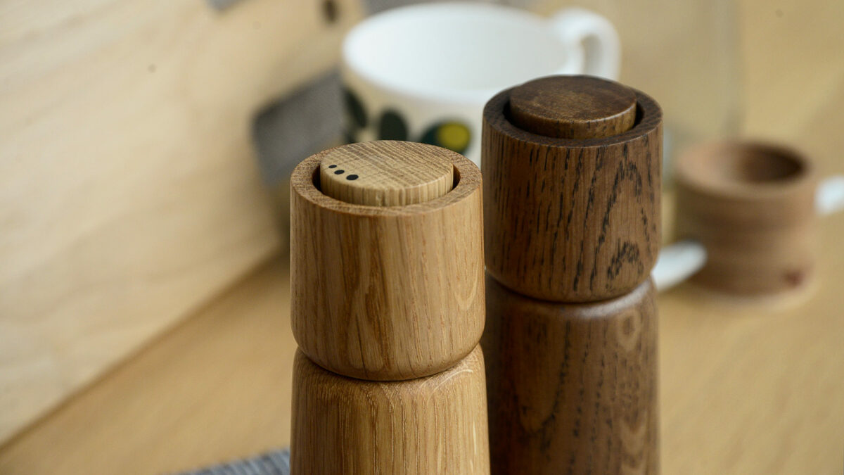 modern wooden salt and pepper grinders showing the tops in close up