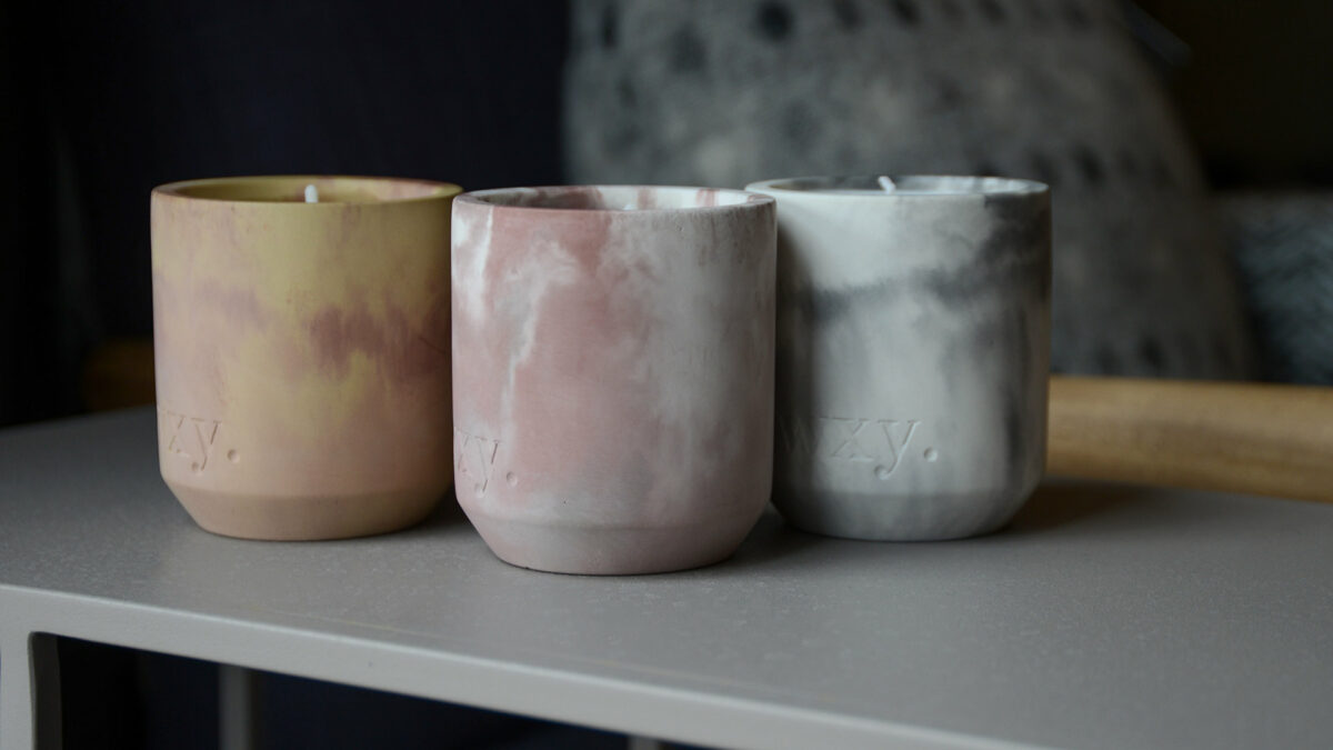 Scented candles in marbled look concrete pots