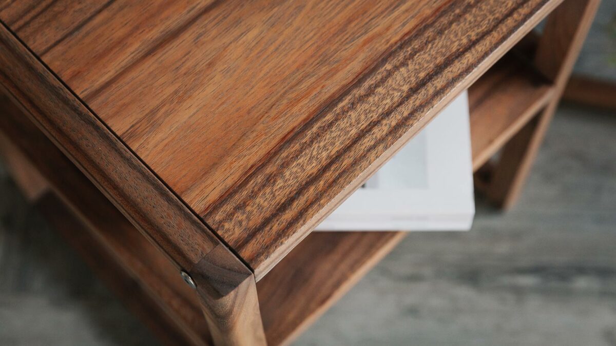 shown from above and in close up a slim dark wood bedside table