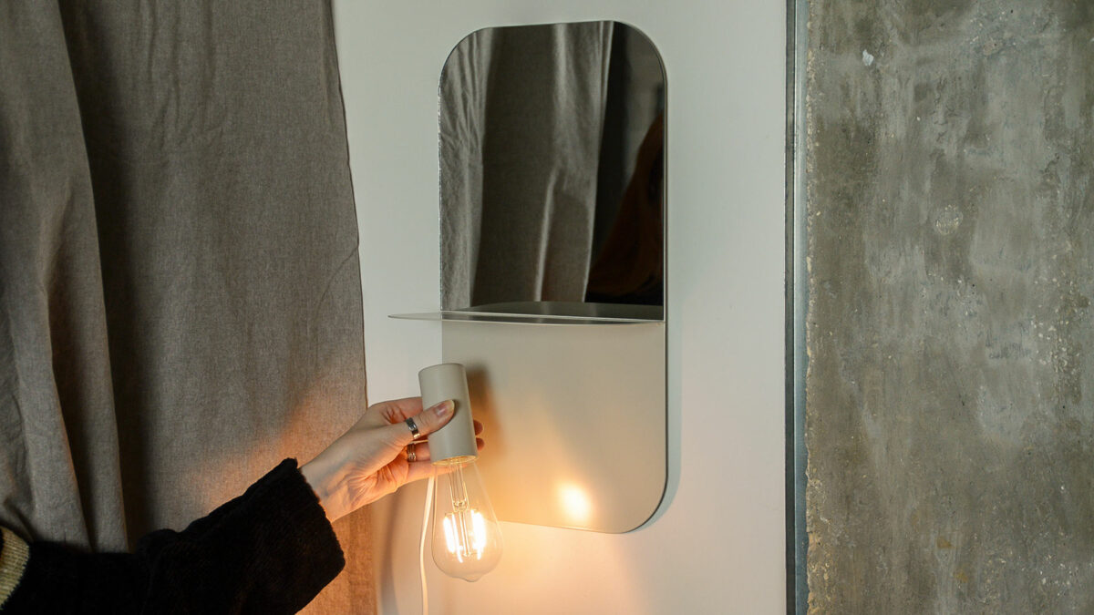 metal bedside shelf in use with hand to show function